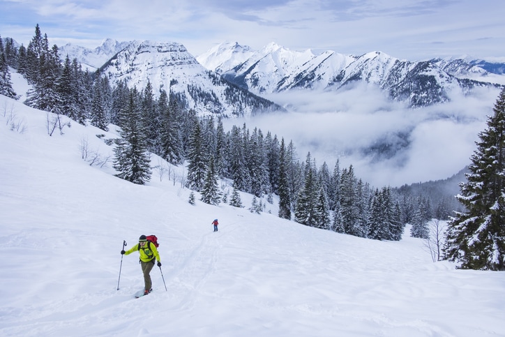 אדם גולש בסקי שלג במורד אחד ההרים שמקיפים את הכפר זיפלד 
