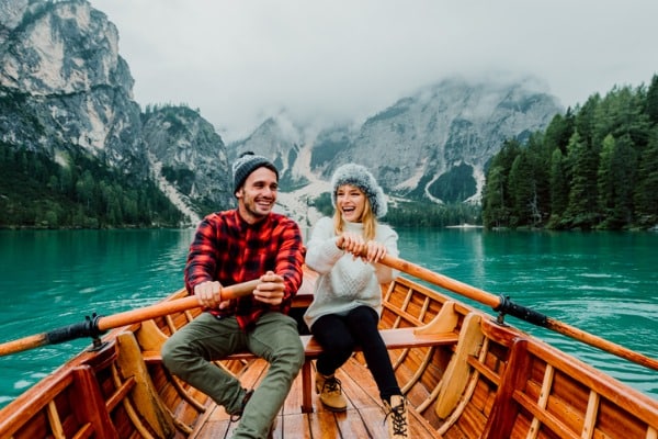 זוג הרפתקני חותר בסירה באגם בהרי האלפים